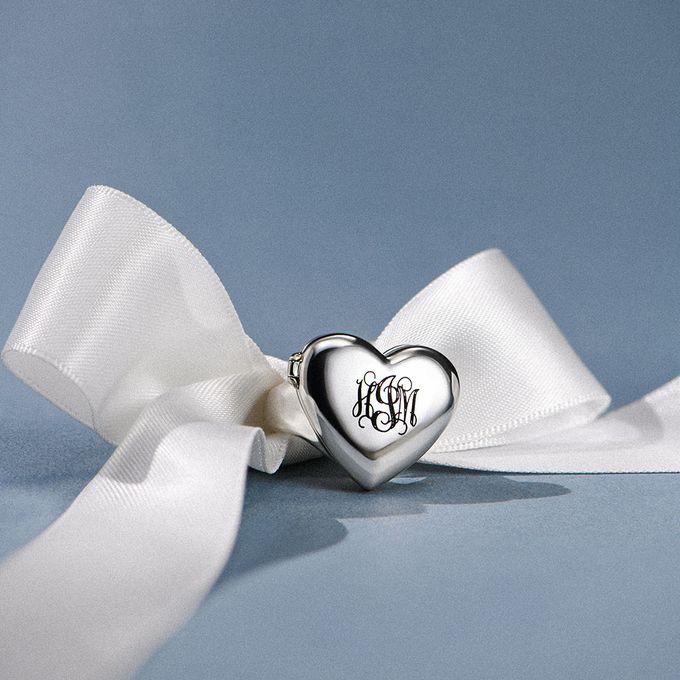 a white ribbon with a heart shaped charm on it