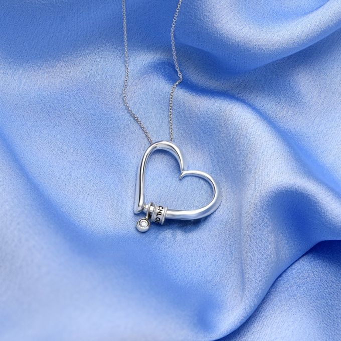 a heart shaped pendant on a blue fabric