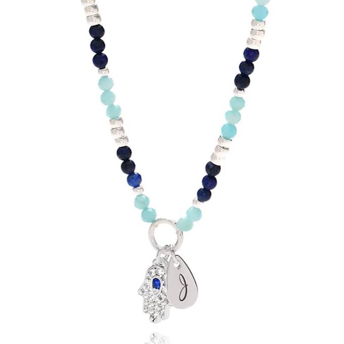 a blue beaded J initial necklace with a silver charm