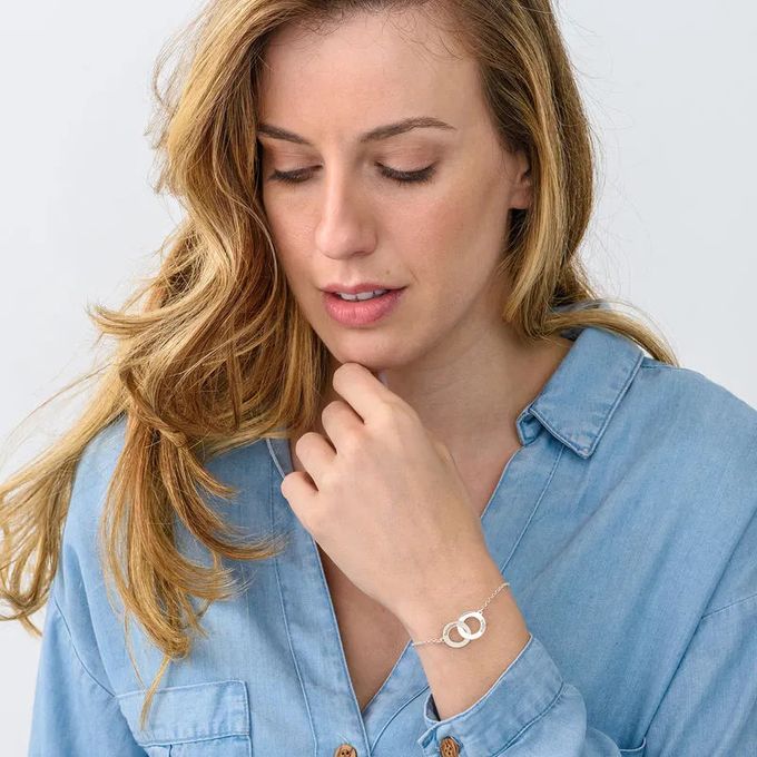 a sterling silver bracelet with an interlocking  heart shaped charms with engraving 