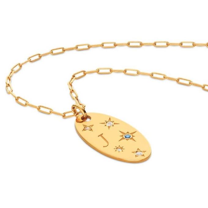 a gold necklace with a star and initial M charm