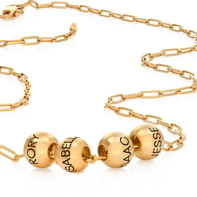 a gold necklace with three balls on it