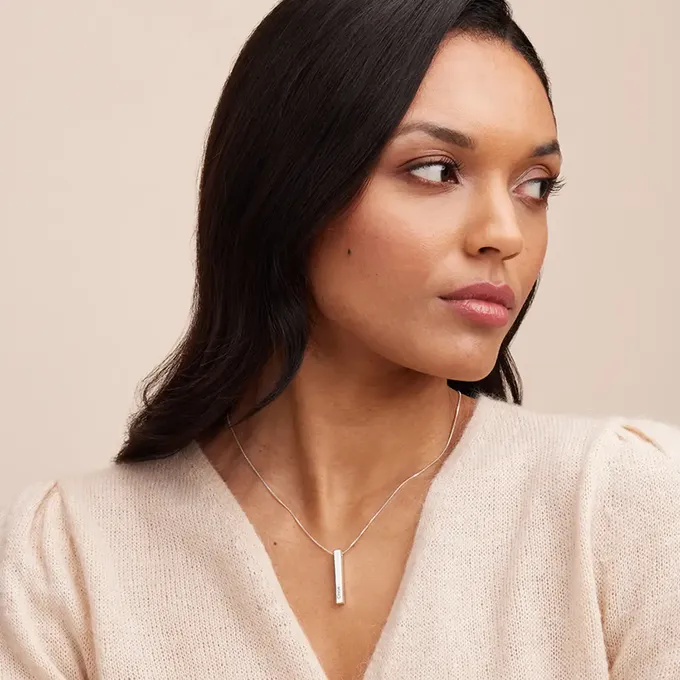 a woman wearing a bar necklace by theo grace