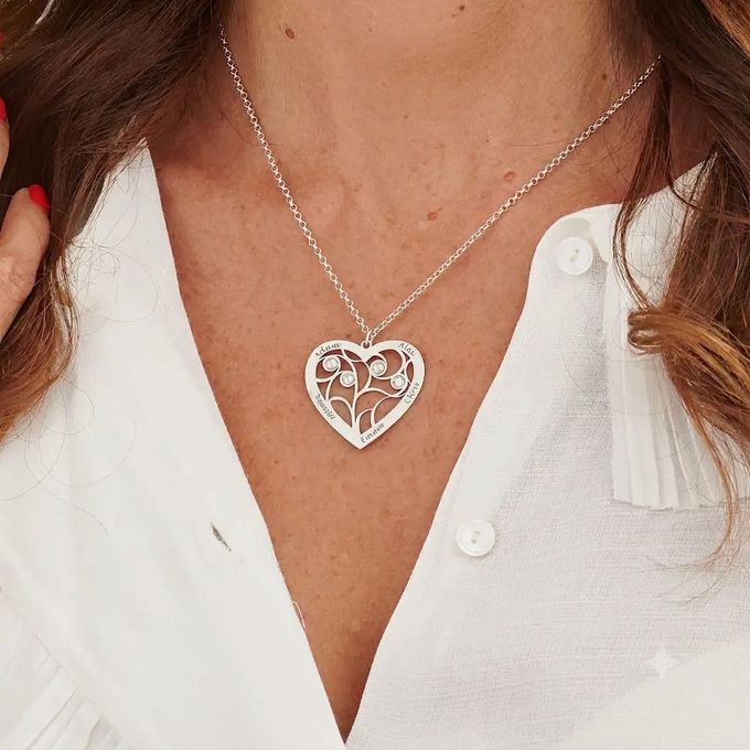 a close up of a woman wearing a heart shaped necklace