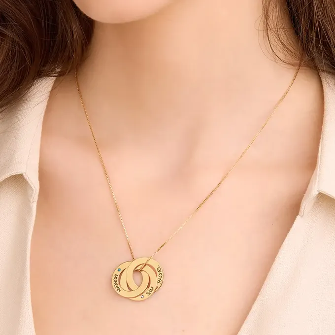 a woman wearing a gold necklace with a russian ring pendant