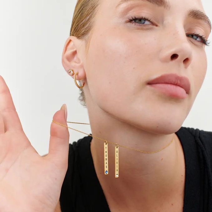 a woman wearing a black shirt and bar necklace