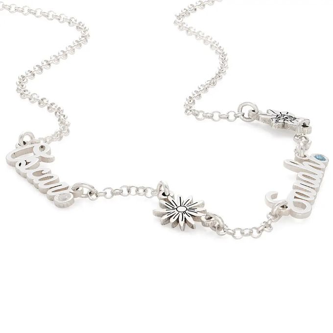a silver necklace with a flower and a name charm