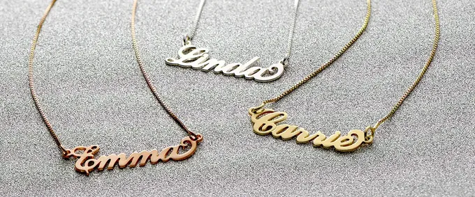 three personalized name necklaces on a table