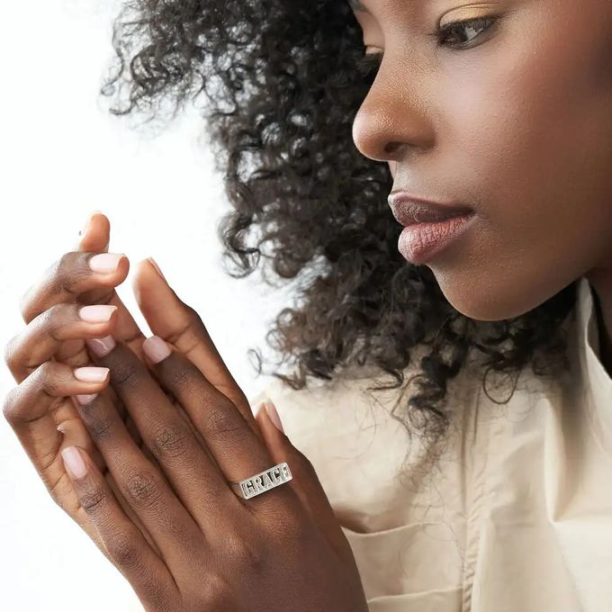 Woman wearing a block silver ring inscribed with "Grace"