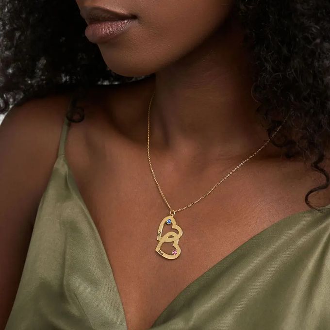 a woman wearing a gold necklace with birthstone and names