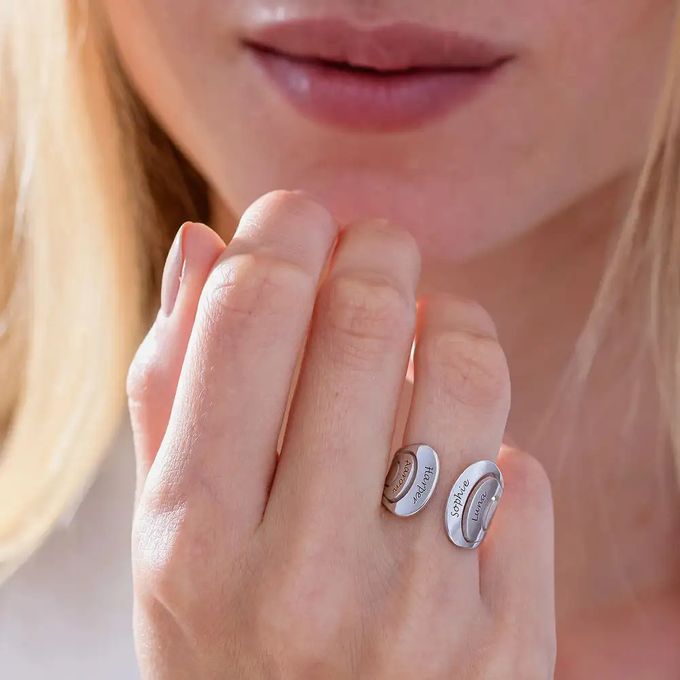 Silver hug ring inscribed with names around a woman's finger