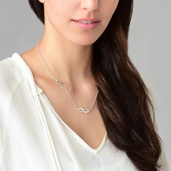 Woman wearing a silver necklace with infinity signs