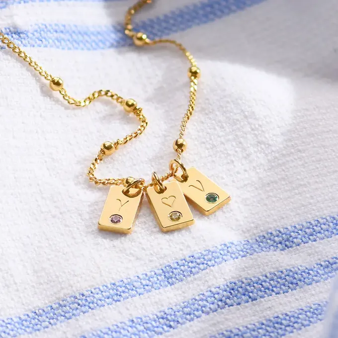Letter necklace sitting on top of a blanket