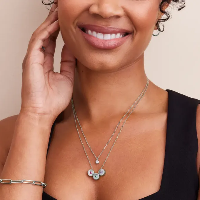 a close up of a person wearing a birthstone necklace