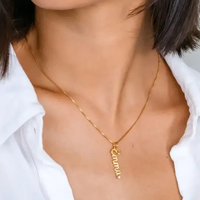Emma Vertical Cursive Name Necklace with Diamond in 18K Gold Vermeil a woman wearing a gold necklace with the word Emma on it