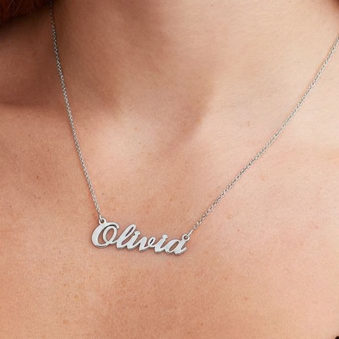 Olivia Hollywood Small Name Necklace in silver a close up of a woman wearing a necklace