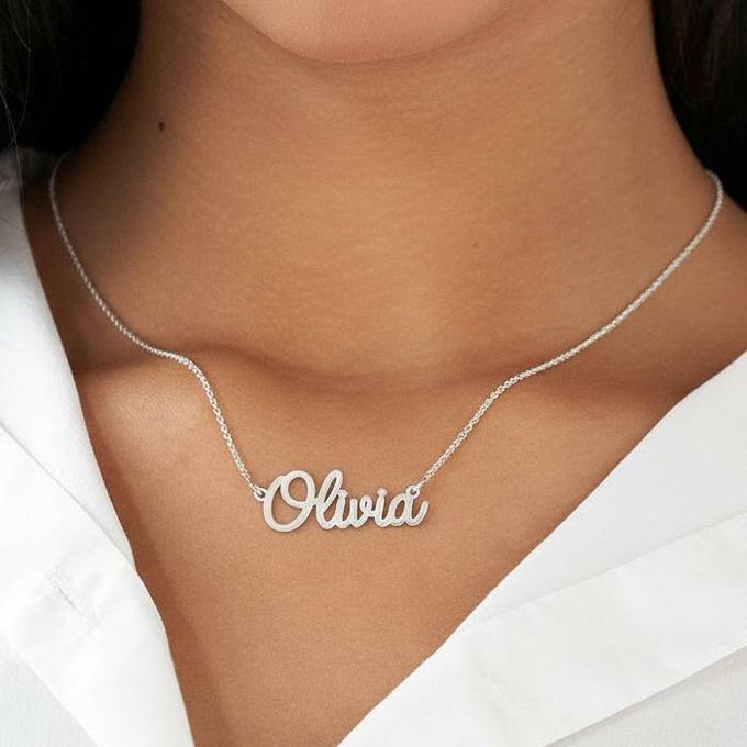 Olivia Name Necklace in Sterling Silver Cursive style a woman wearing a silver necklace with the word Olivia on it