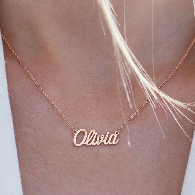 a close up on a woman wearing an Olivia name necklace