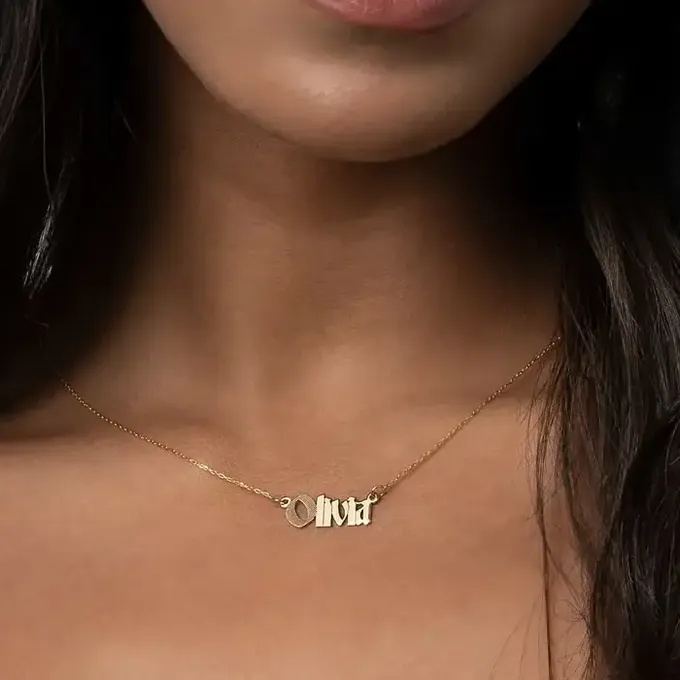 a close up of a woman wearing Olivia gold necklace