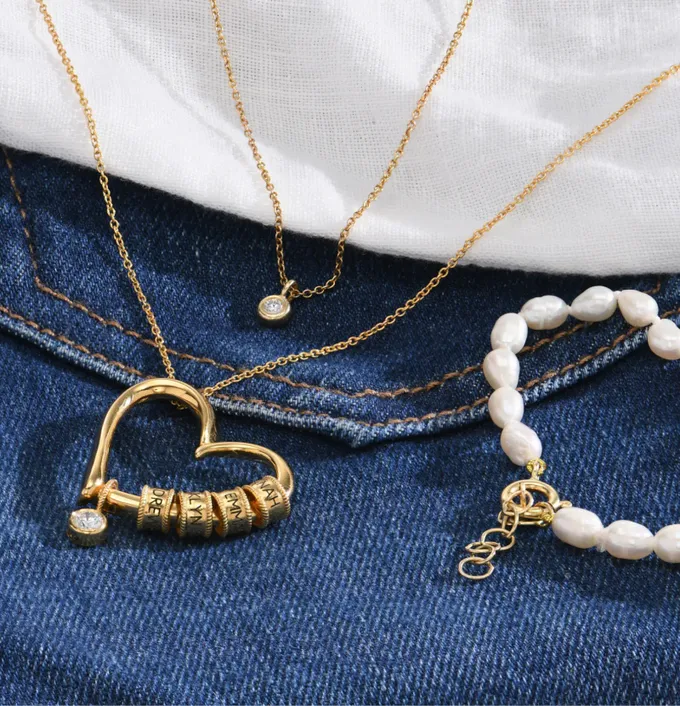 gold necklaces and pearl bracelet on jeans
