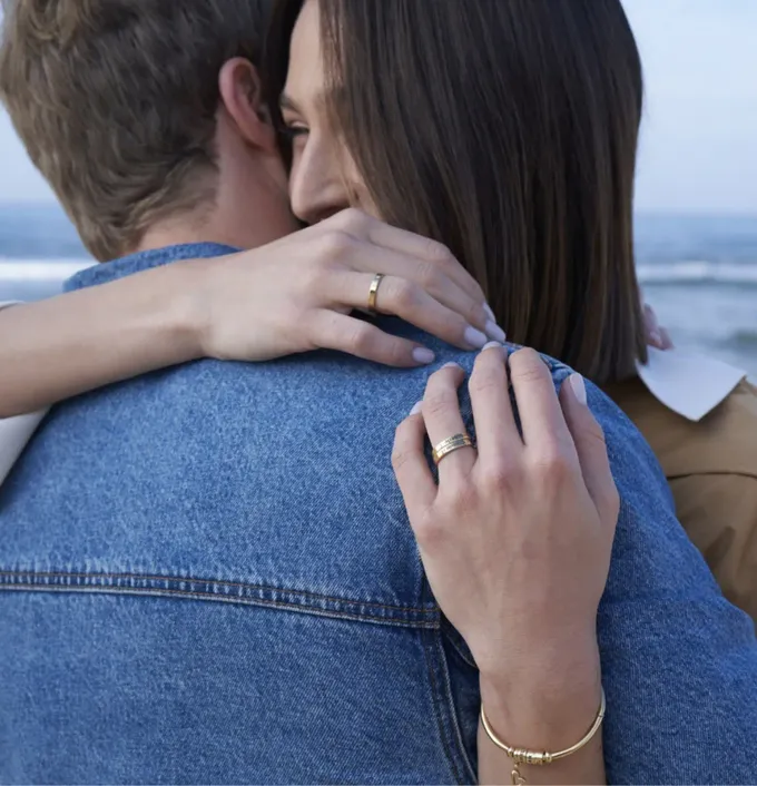 a man and woman embracing each other on the beach
