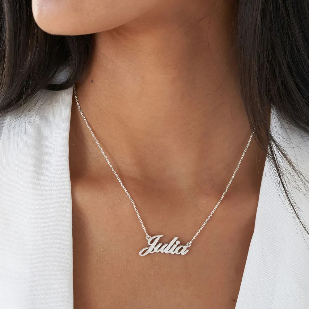 Silver name necklace that reads "Julia" around a woman's neck