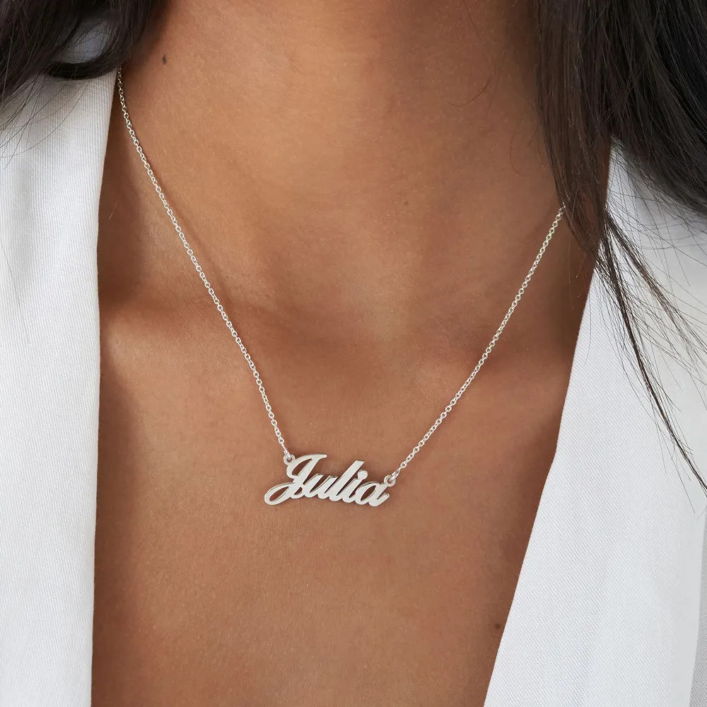 Close-up of a silver name necklace that reads "Julia" around a woman's neck