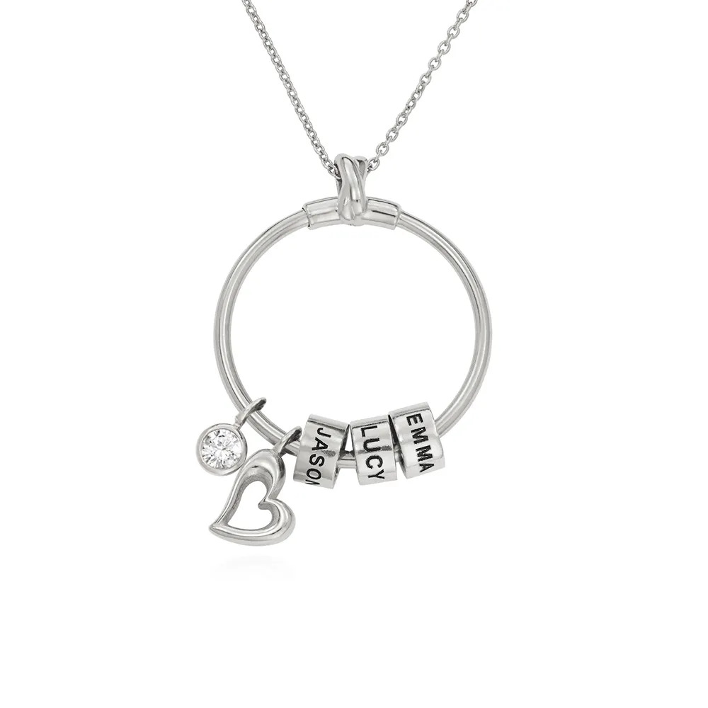 A stock image of a silver necklace with a circle pendant with inscribed beads