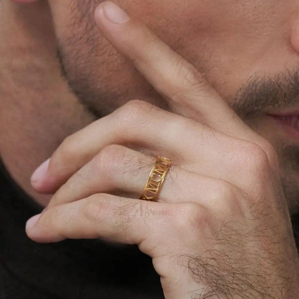 Close up of a man's hand while wearing a gold ring with Roman numerals