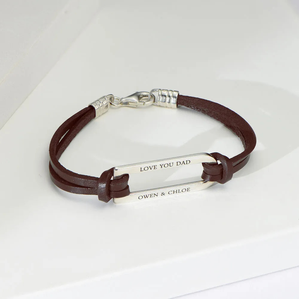 Stock image of  a brown leather bracelet with an inscribed silver bar 