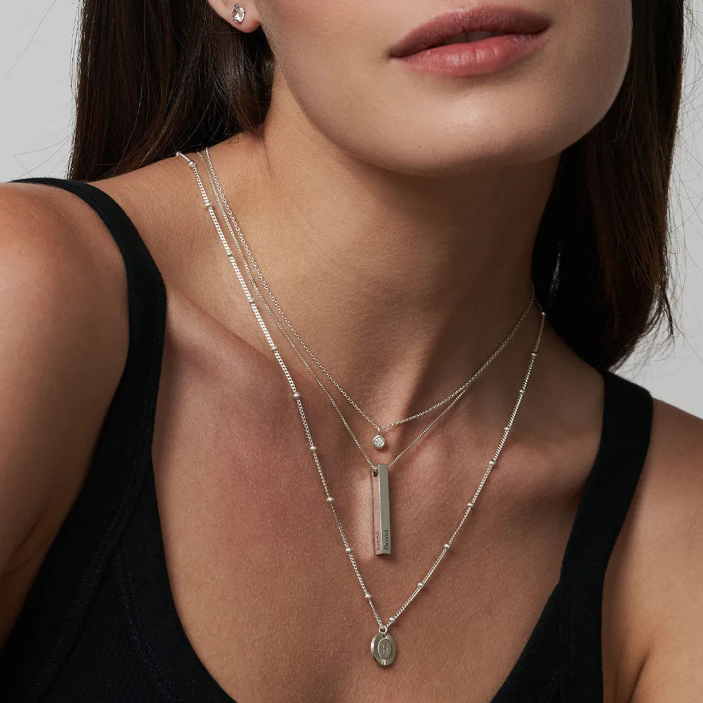 Woman wearing multiple silver necklaces with pendants