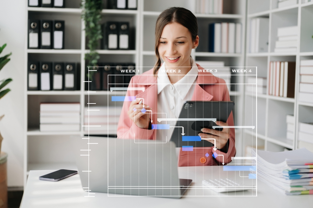 Facility manager sitting at a desk and using real-time data on her computer to improve office space efficiency