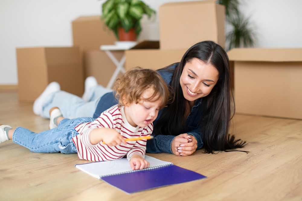 A woman teaching a child to draw, pactising their fine motor skills