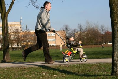 Parent and child enjoying a day at the park, child riding a tricycle