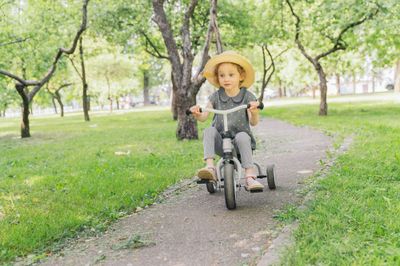 A little boy riding a bike down a path.