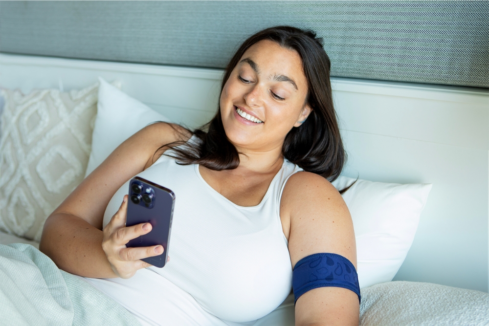 a woman laying in bed holding a cell phone