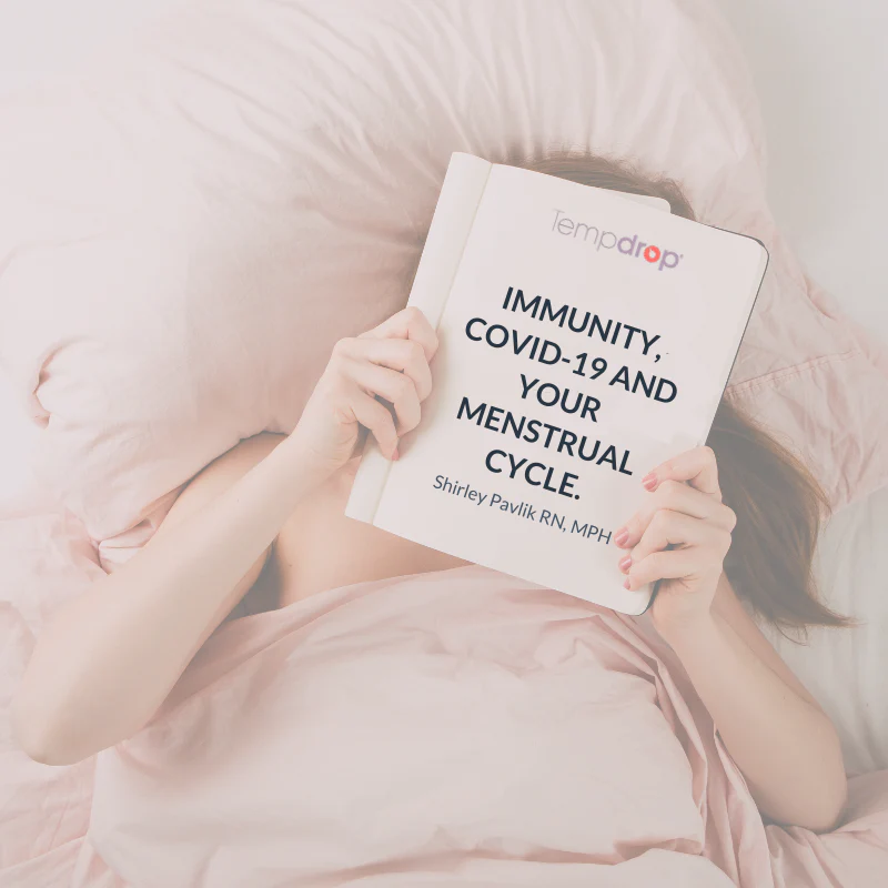 a woman laying in bed holding a book