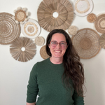 a woman standing in front of a wall of woven circles