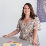 a woman sitting at a table with a cake in front of her