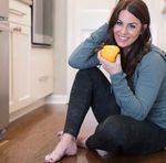 a woman sitting on the floor holding a piece of food