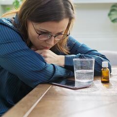 a woman sitting at a table with a tablet