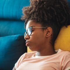 a girl with glasses sitting in a chair