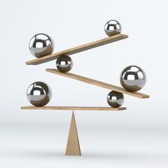 a balance scale with balls on top of it