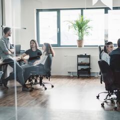 a group of people sitting around a table in an office