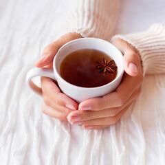 a woman holding a cup of coffee in her hands