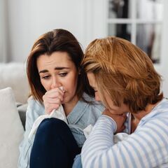 a couple of women sitting on top of a couch