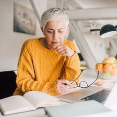 a woman sitting at a table with a laptop