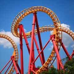 a red and yellow roller coaster at a theme park