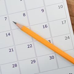 a pencil sitting on top of a calendar