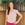 a woman standing in front of a wooden fence